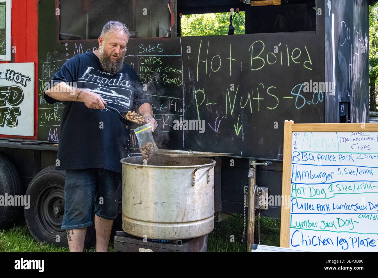 Propriétaire de food truck servant des cacahuètes bouillies chaudes lors d'une célébration du 4 juillet au parc national de Vogel dans les montagnes de Géorgie du Nord. (ÉTATS-UNIS) Banque D'Images