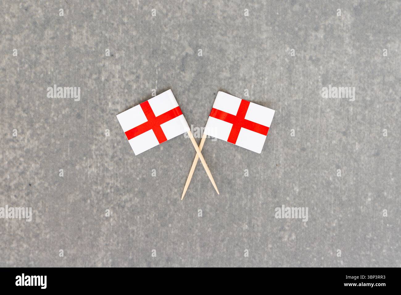 Deux drapeaux anglais croisés sur des bâtons sur une surface en béton Banque D'Images