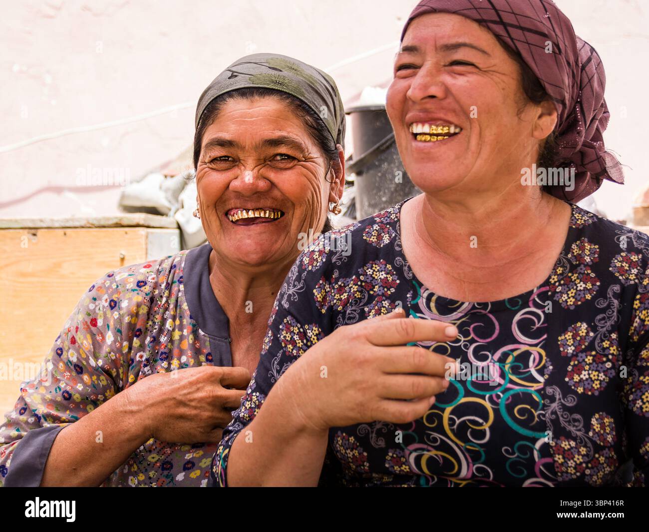 Khiva, Ouzbékistan - 12 juillet 2024 : deux femmes ouzbèkes rient, montrant des dents d'or traditionnelles – portrait culturel Banque D'Images