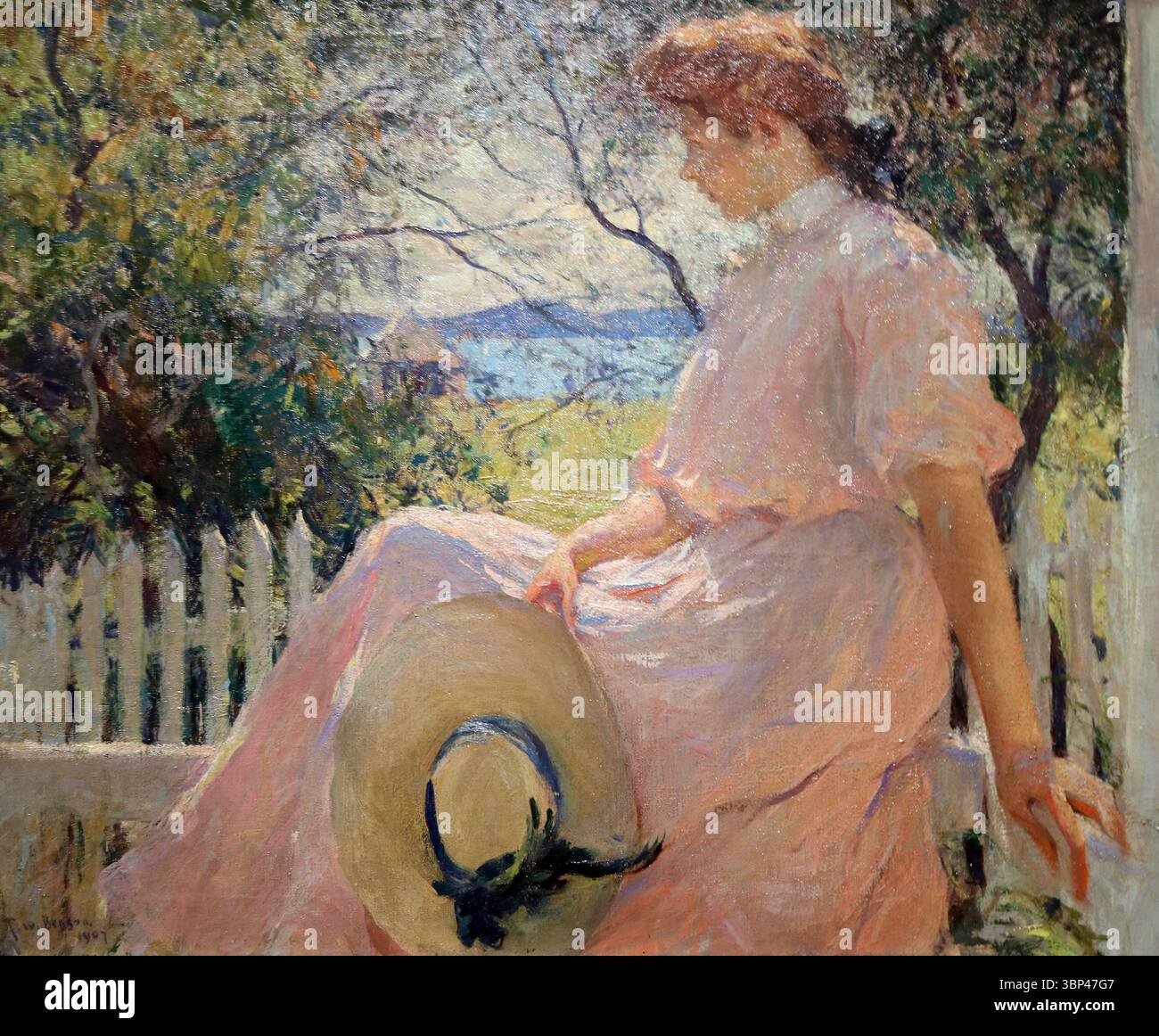 Eleanor de Frank Weston Benson (1862 ?1951), représentant une femme dans une robe rose assise à l'extérieur avec un chapeau sur les genoux. William McGregor Paxton était un artiste américain connu pour son style Boston School, qui mettait l'accent sur la précision académique, le brossage raffiné et les représentations élégantes de figures, souvent des femmes dans des contextes domestiques. 1907. Banque D'Images
