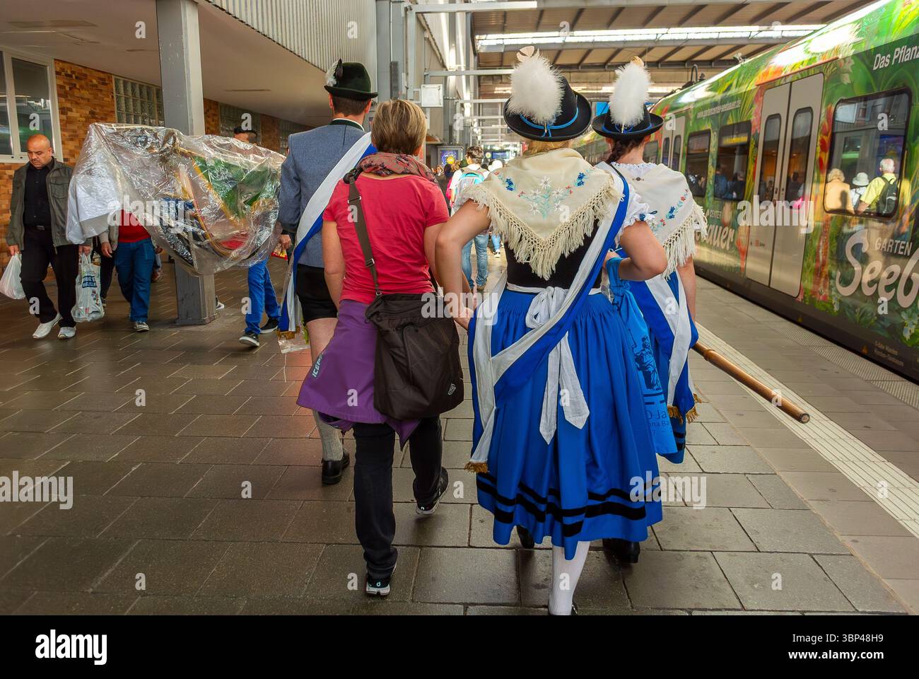 Munich, Allemagne, personnes de groupe, femmes allemandes, marcher dans la plate-forme de la gare en costumes traditionnels Banque D'Images