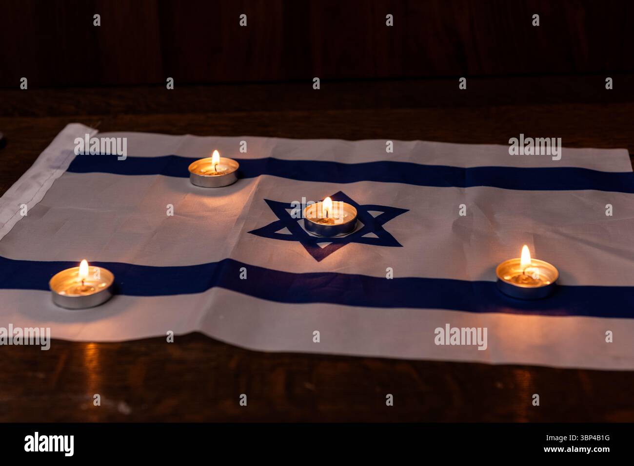 Des bougies commémoratives brillent sur un drapeau israélien pour marquer les fêtes juives de Yom HaZikaron, le jour du souvenir et le jour du souvenir de l'Holocauste en Israël. Banque D'Images