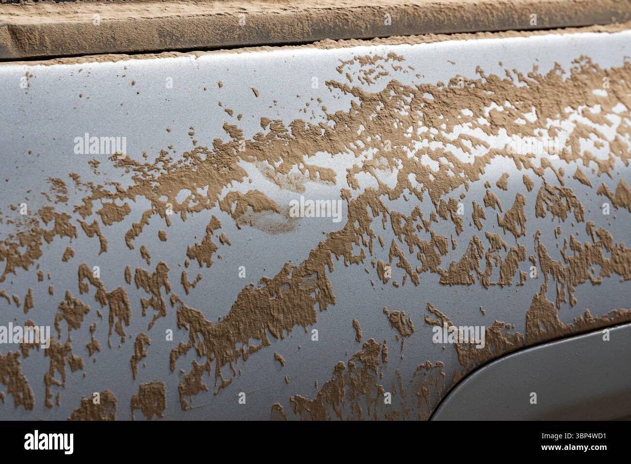 Gros plan boueux sur une porte de voiture. Pièce de voiture sale dans la poussière. Banque D'Images