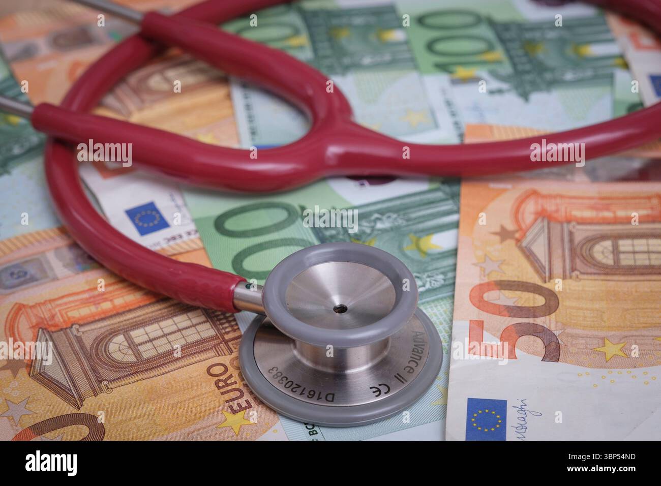 Un stéthoscope sur plusieurs billets en euros. Image symbolique de l'augmentation des coûts de santé, des dépenses médicales et des charges financières dans le système de santé. Banque D'Images