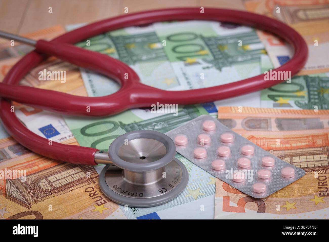Un stéthoscope sur plusieurs billets en euros. Image symbolique de l'augmentation des coûts de santé, des dépenses médicales et des charges financières dans le système de santé. Banque D'Images