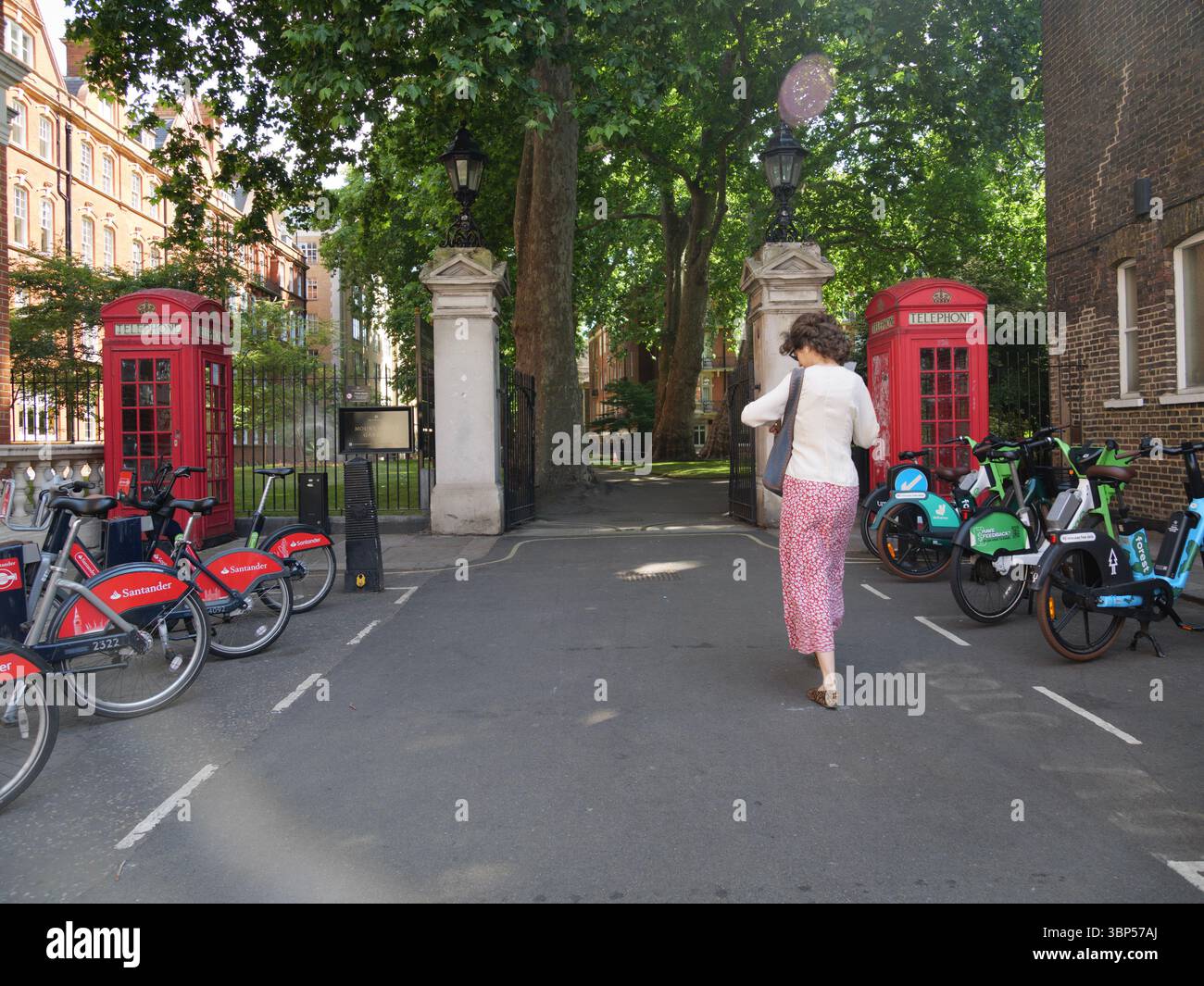 Les piétons traversent l’entrée des jardins de Mount Street à Mayfair, Londres, Royaume-Uni, un espace vert élégant et tranquille niché dans l’un des quartiers les plus exclusifs de la capitale. Banque D'Images