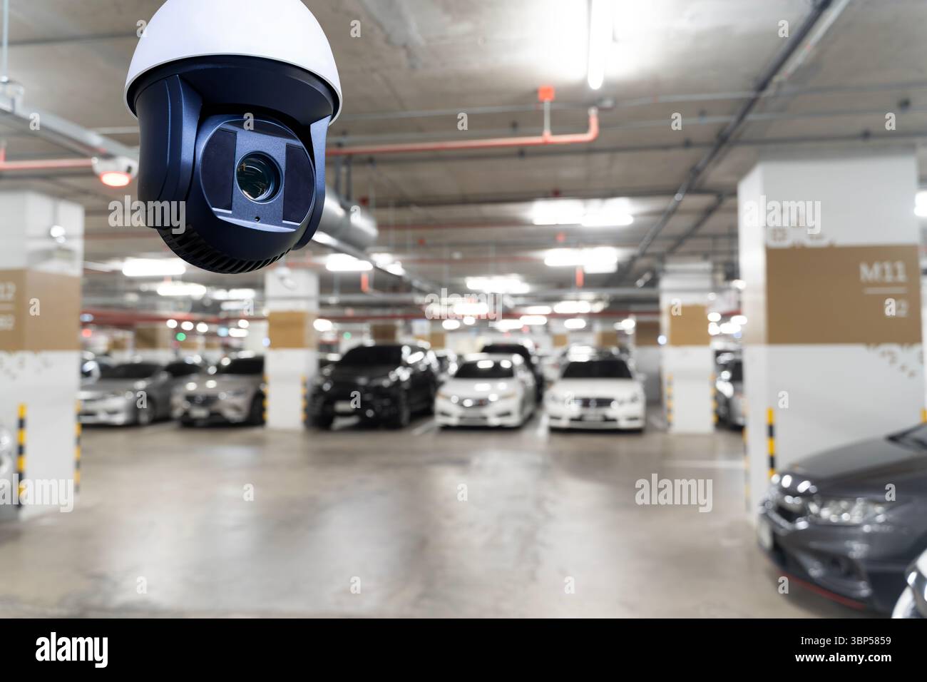 Caméra de sécurité CCTV installée dans le garage de stationnement intérieur avec plusieurs voitures garées en arrière-plan, concept de surveillance de la protection de sécurité de surveillance Banque D'Images