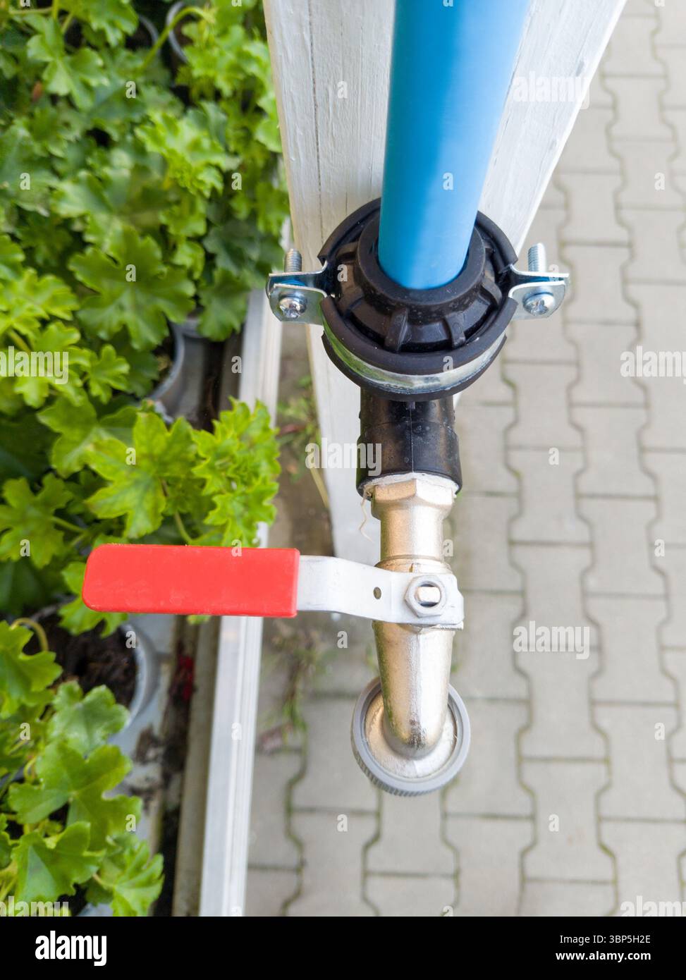 Robinet d'eau extérieur avec poignée rouge Banque D'Images