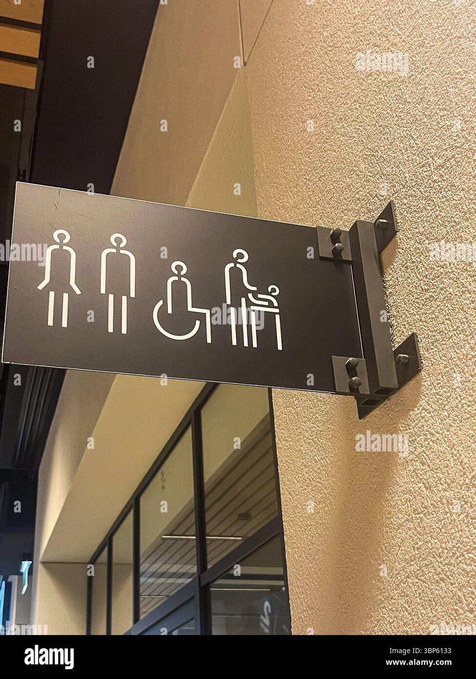 Le panneau des toilettes affiche des symboles pour hommes, femmes, accessibles et familiaux, mettant l'accent sur l'inclusivité et l'accessibilité dans les environnements publics Banque D'Images