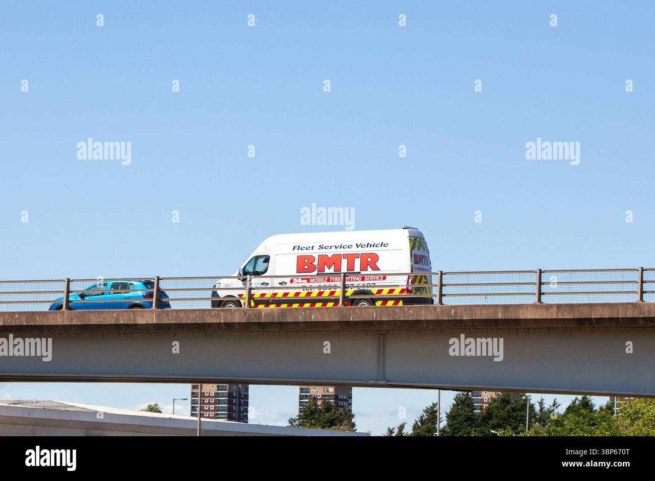 Une camionnette de service mobile de montage de pneus BMTR et une voiture bleue parcourent un pont en béton préfabriqué sur la rocade A5 à Tamworth, au Royaume-Uni. Banque D'Images