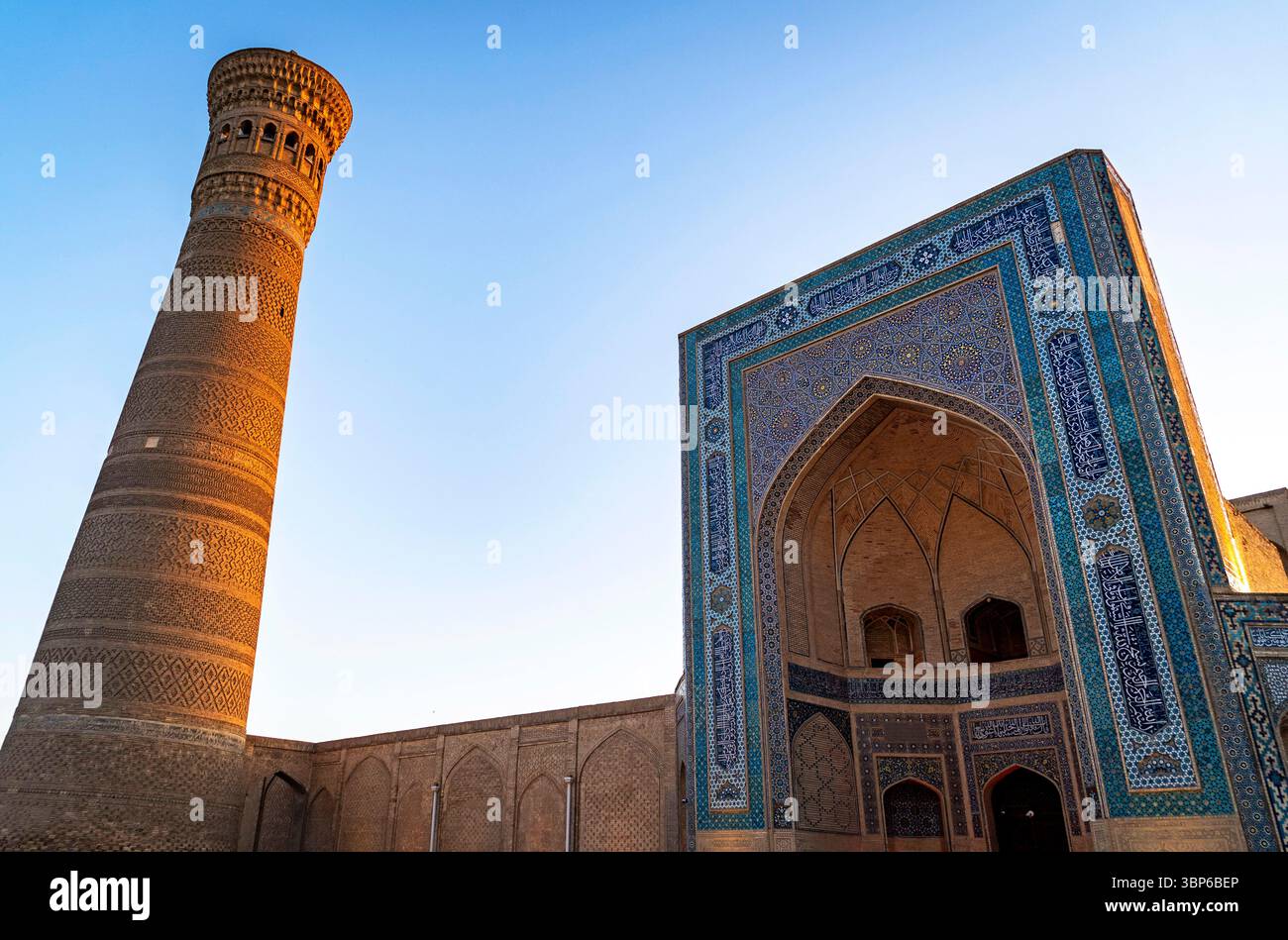 Un site architectural historique avec un grand minaret et une entrée magnifiquement carrelée. La structure présente des motifs complexes et des dessins typica Banque D'Images Un site architectural historique avec un grand minaret et une entrée magnifiquement carrelée. La structure présente des motifs complexes et des dessins typica Banque D'Images