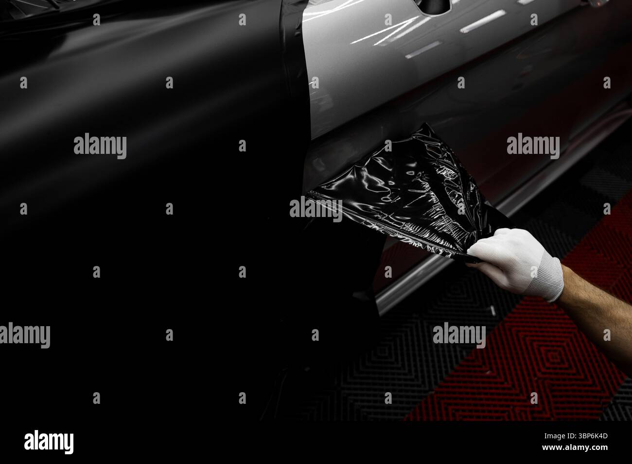 L'application d'habillage modifie l'apparence du véhicule. Emballage en vinyle pour voiture à panneau complet. L'installation à grande échelle de film vinyle transforme l'extérieur du véhicule Banque D'Images