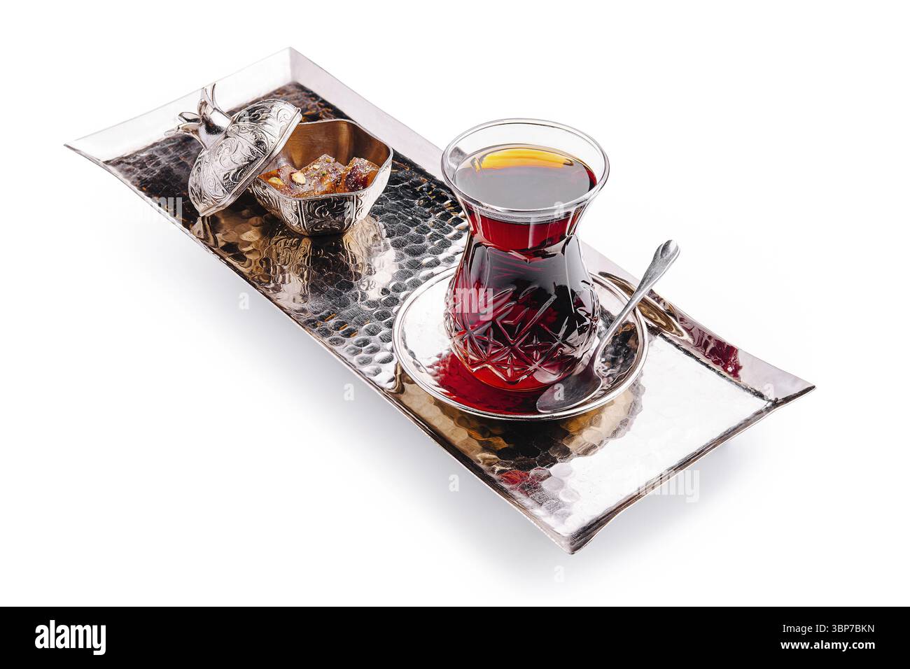 Nourriture, Un plateau magnifiquement disposé tient un verre de thé turc à côté d'un petit bol de bonbons, mettant en valeur l'élégance d'un service de thé traditionnel Banque D'Images