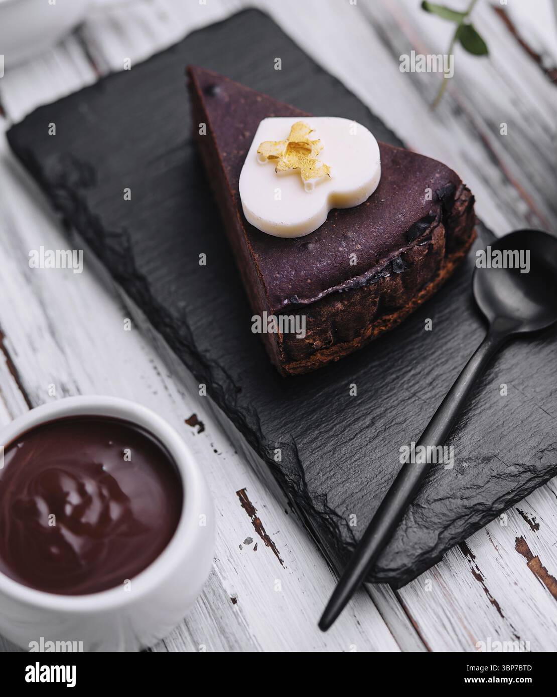 Nourriture, tranche de gâteau Sacher et crème au chocolat sur bois Banque D'Images