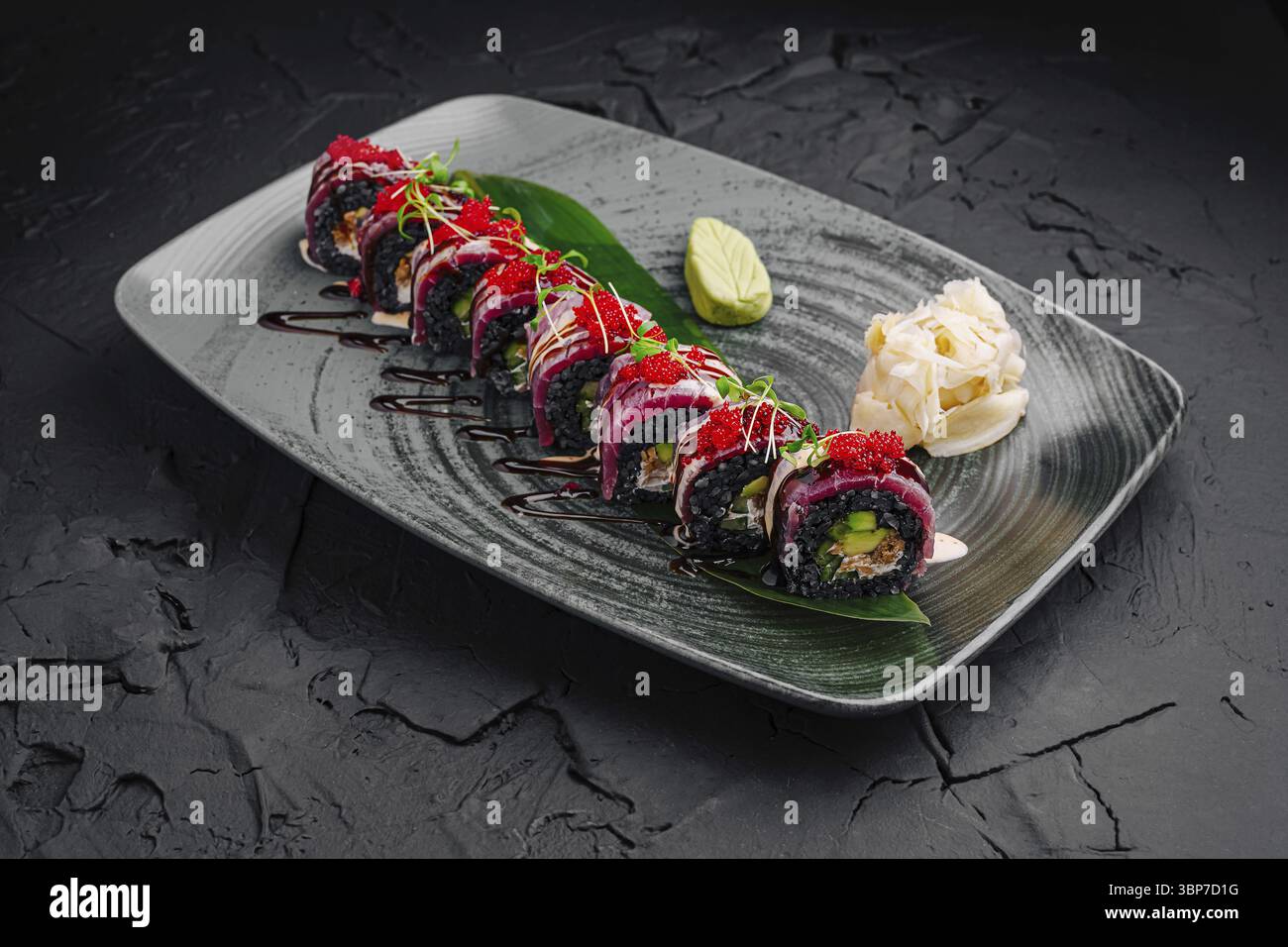 Nourriture, Une variété de rouleaux de sushi colorés sont agencés avec art sur une assiette décorative élégante. Les garnitures adjacentes comprennent du wasabi et du gingembre mariné, spectacle Banque D'Images