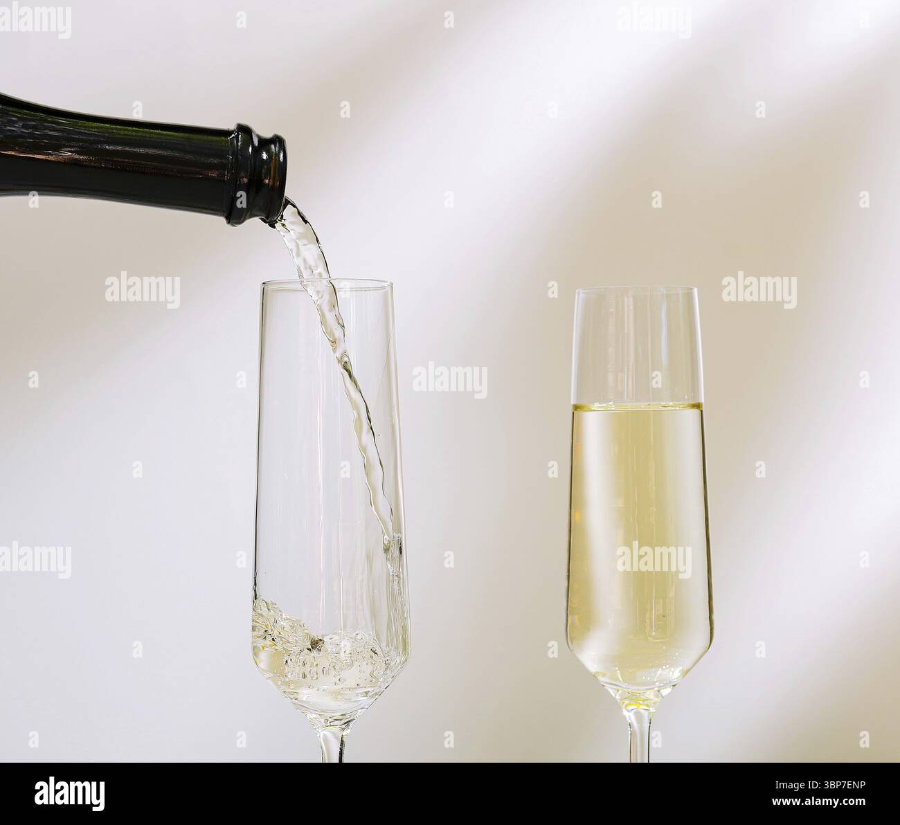 Nourriture, Une bouteille verse une boisson pétillante dans un grand verre à flûte. Le cadre suggère une occasion festive, renforçant l'ambiance de joie et d'anticipation Banque D'Images