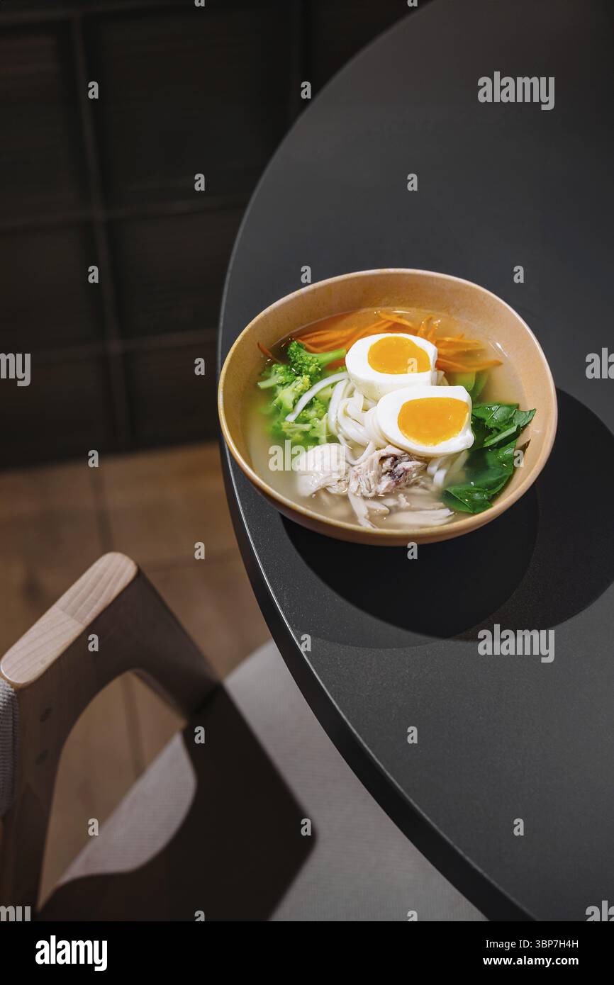 Nourriture, soupe salée de nouilles au poulet avec légumes et œufs servis dans un cadre moderne de restaurant Banque D'Images
