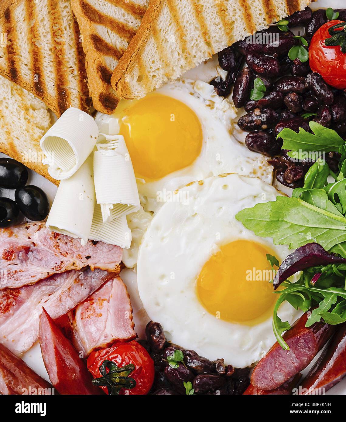 Nourriture, vue aérienne d'une assiette copieux avec œufs, bacon, pain grillé et légumes frais Banque D'Images