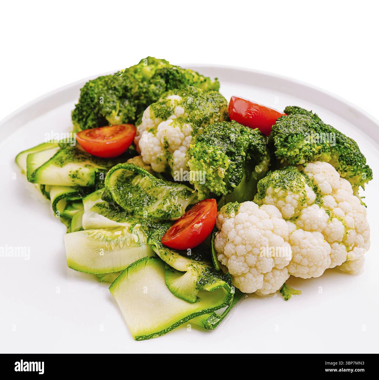 Nourriture, Un assortiment coloré de brocoli et de chou-fleur est servi sur une assiette blanche. Les légumes sont vibrants et garnis de tomates cerises, sho Banque D'Images