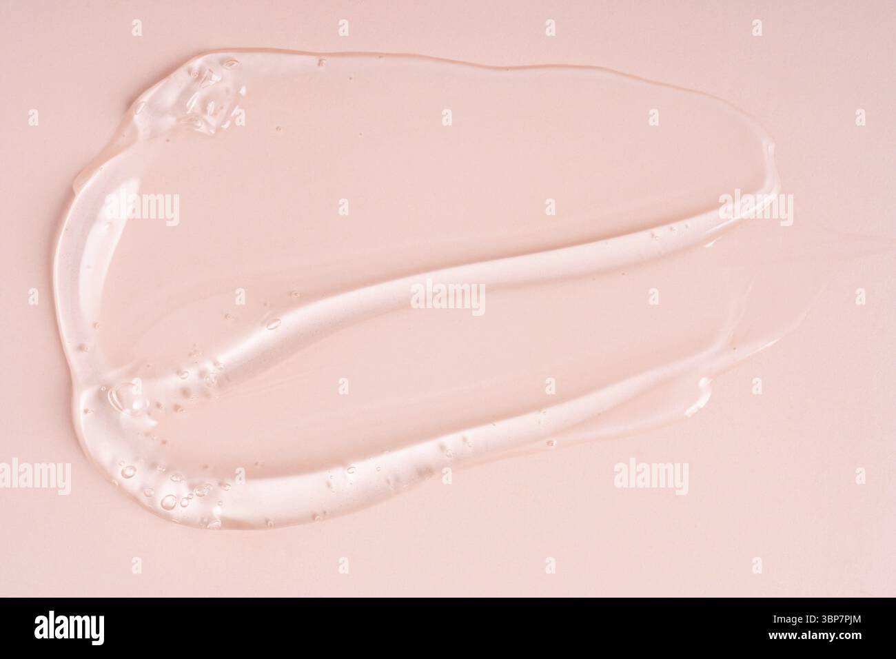 Gros plan de gel cosmétique liquide rose ou de tampons de maquillage sérum avec une texture brillante et brillante sur un fond rose lisse Banque D'Images
