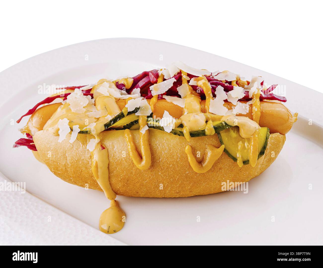 Nourriture, hot dog appétissant garni de sauces et de légumes sur une assiette ovale, isolé sur fond blanc Banque D'Images