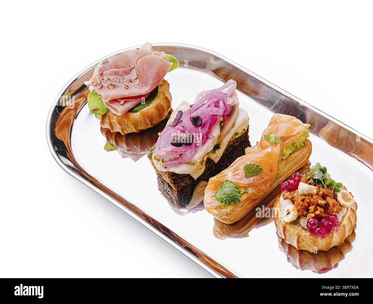Nourriture, canapés délicats disposés sur un plateau d'argent comportent diverses garnitures. Chaque friandise en bouchée met en valeur des saveurs uniques, parfaites pour un style élégant Banque D'Images