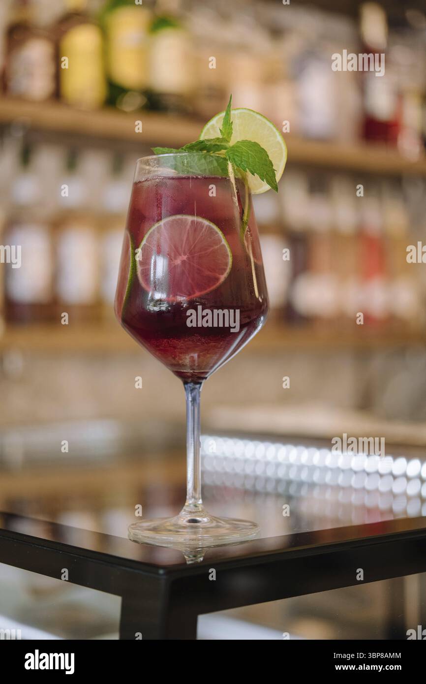 Nourriture, cocktail rose froid avec pamplemousse frais, citron vert et glaçons sur la table du restaurant Banque D'Images