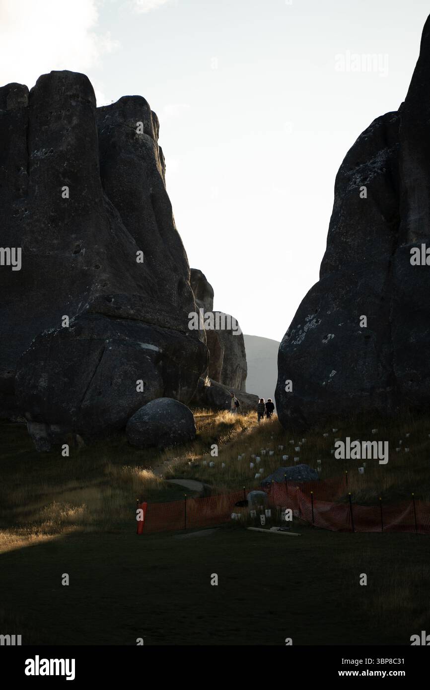 Une figure solitaire se dresse dans le passage étroit de Castle Hill, en Nouvelle-Zélande, éclipsé par les immenses formations rocheuses. La photo capture l'échelle de th Banque D'Images