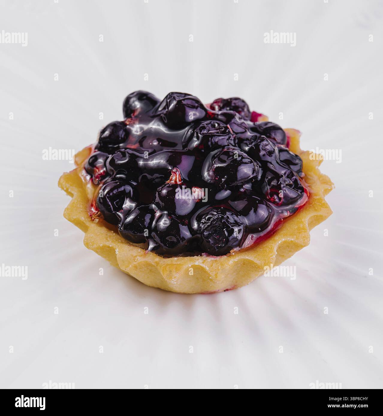 Nourriture, tarte aux myrtilles fraîchement cuite suintant de baies juteuses, présentée sur une surface blanche immaculée Banque D'Images