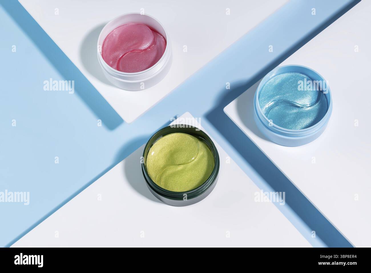 Plaques cosmétiques hydrogel pour les yeux pour les soins de la peau sur les podiums blancs tendance sur le bleu. Produit pour le soulèvement de la peau, les rides anti-âge. taches sous les yeux dans un gr Banque D'Images