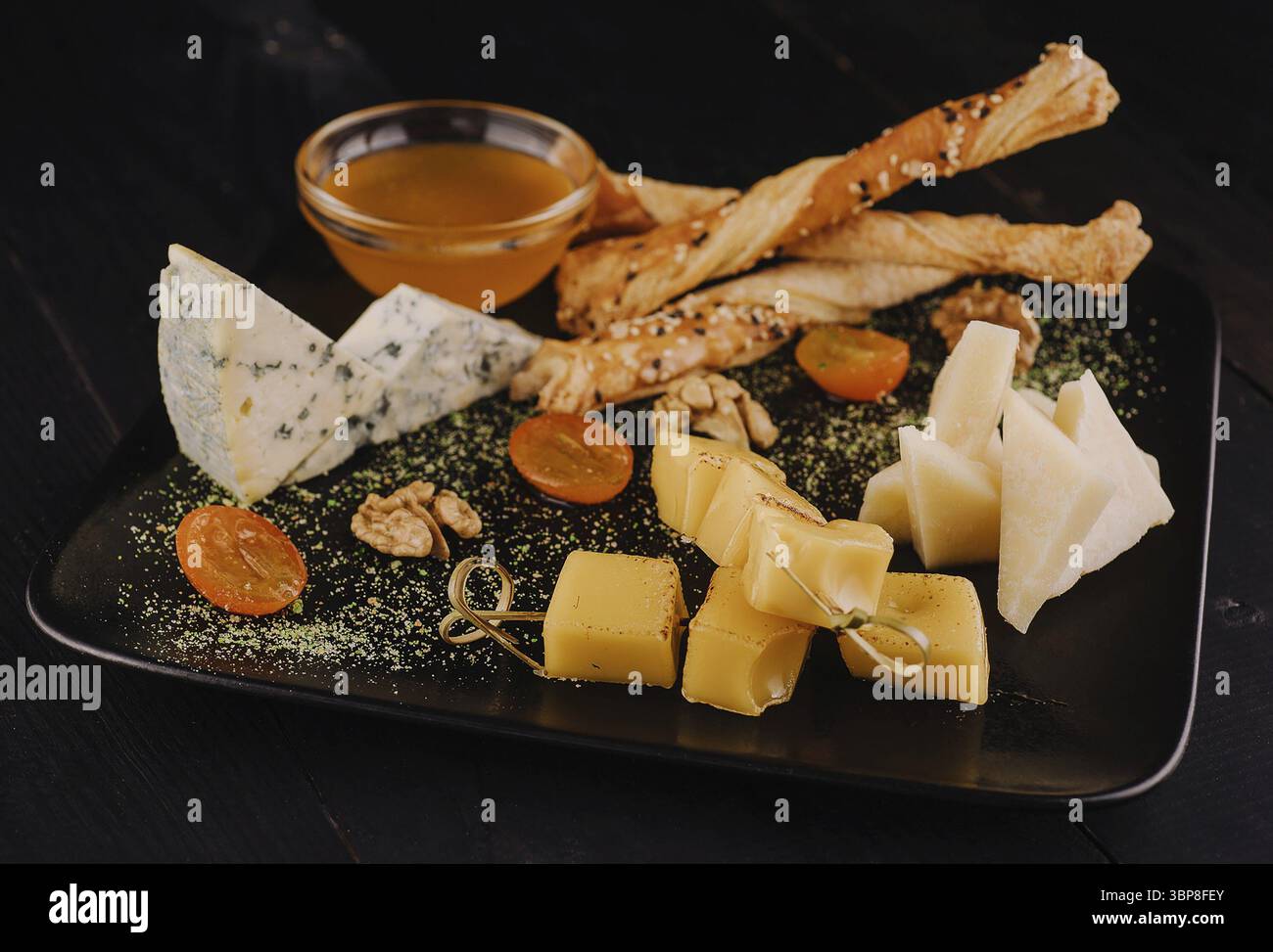 Nourriture, assiette de fromage sur assiette noire Banque D'Images