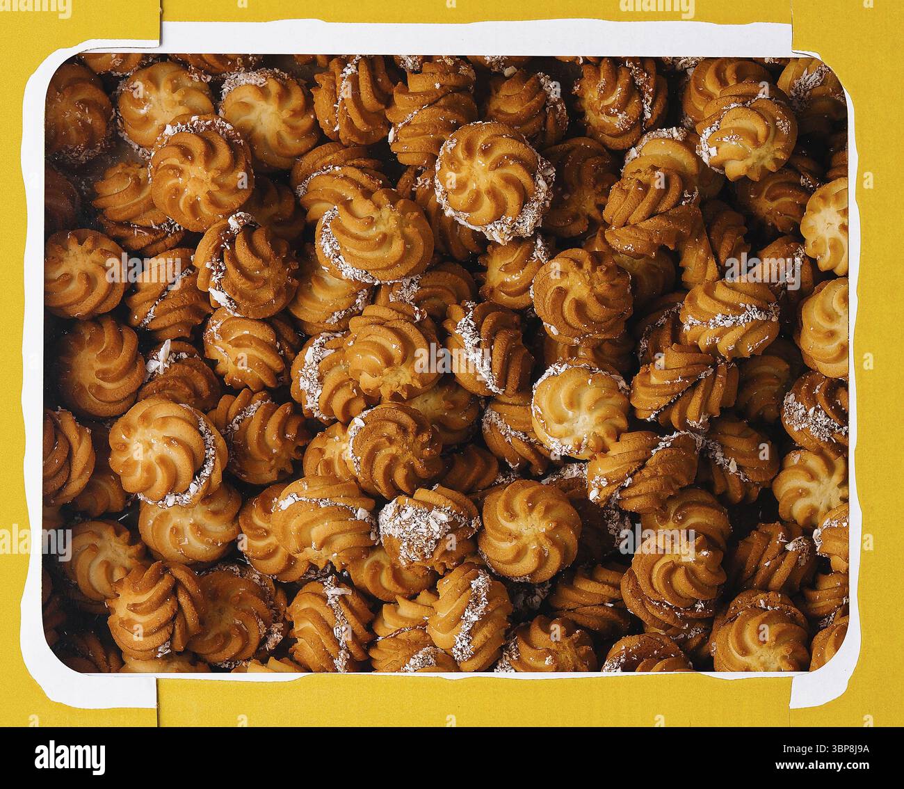Nourriture, vue de dessus d'une boîte jaune remplie de biscuits bruns dorés gros plan Banque D'Images