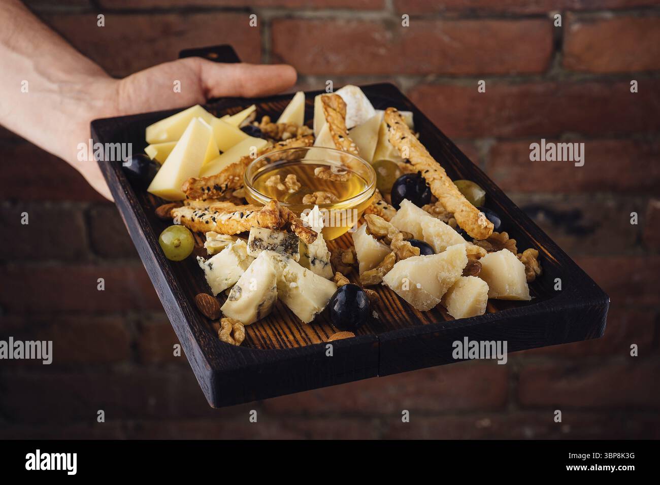 Nourriture, assiette de fromage avec miel, raisins et noix Banque D'Images