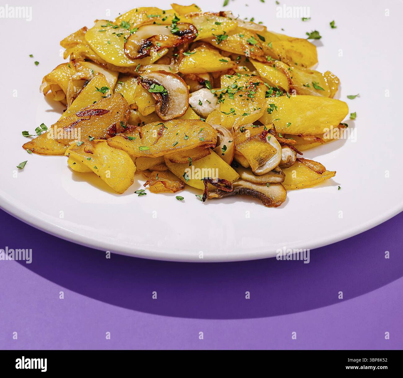 Nourriture, Un plat vibrant avec des pommes de terre frites croustillantes dorées, des champignons sautés et une pincée d'herbes fraîches. Ce repas appétissant est parfait Banque D'Images