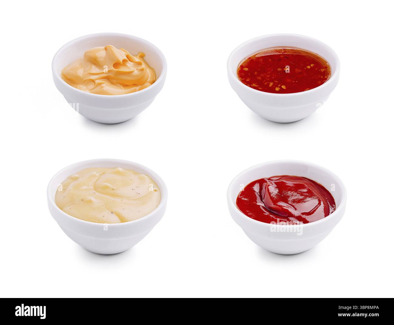 Nourriture, quatre petits bols blancs sont remplis de diverses sauces. Les sauces comprennent une sauce orange crémeuse, une sauce rouge épicée, une sauce blanche épaisse et un t Banque D'Images