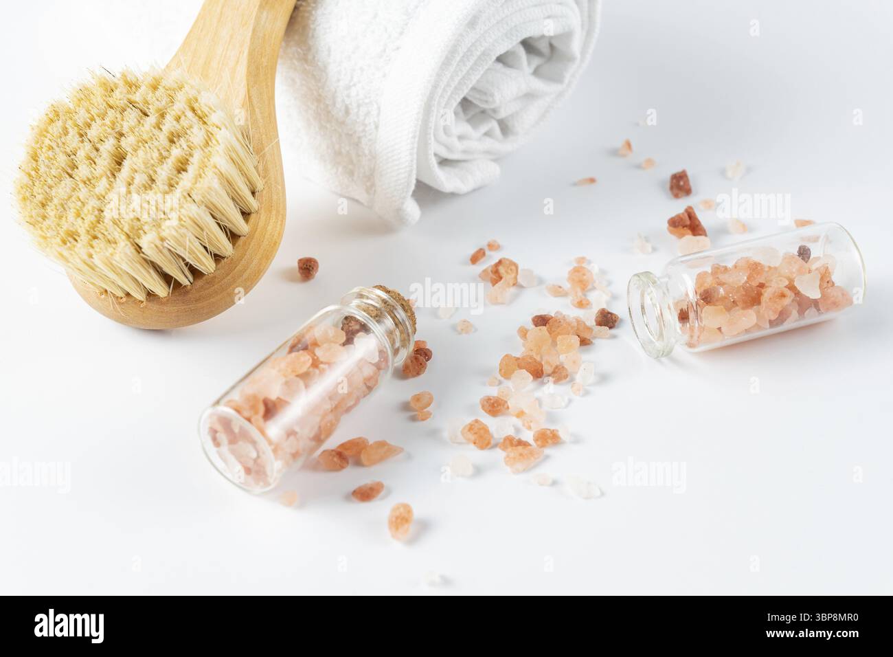 Concept de soins spa. Produits cosmétiques naturels et biologiques de spa, brosse de massage et sel hymalayan rose sur table blanche fond de spa Banque D'Images
