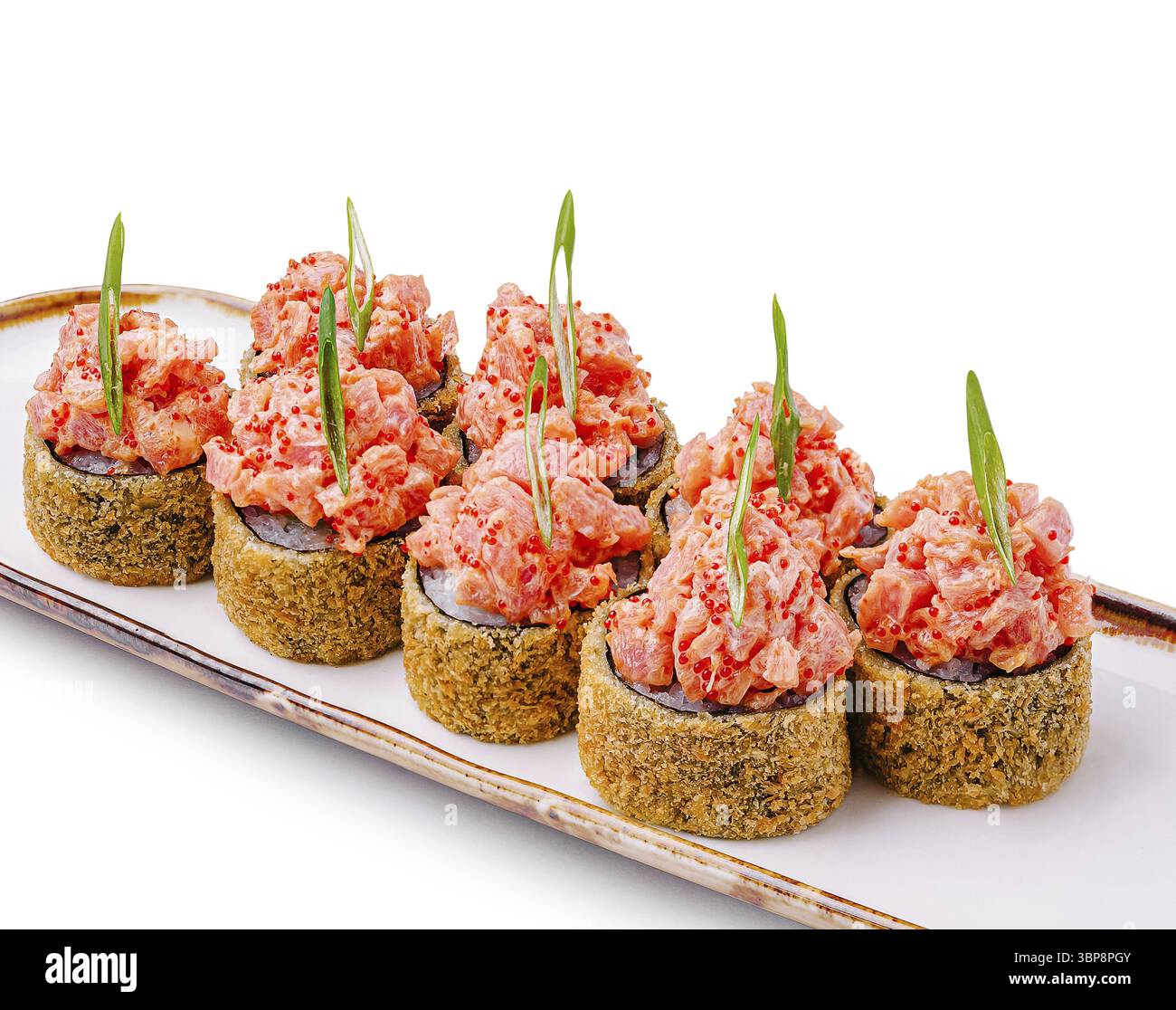 Nourriture, délicieux rouleaux de sushi sont disposés sur un plateau blanc. Chaque pièce est garnie d'une généreuse quantité de fruits de mer épicés et garnie d'oni vert Banque D'Images