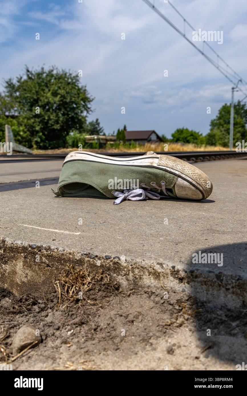 Chaussures de sport vertes près des voies ferrées, une personne heurtée par les voies ferrées à un passage piétonnier, un passage à niveau non surveillé, un suicide s'est jeté en dessous Banque D'Images
