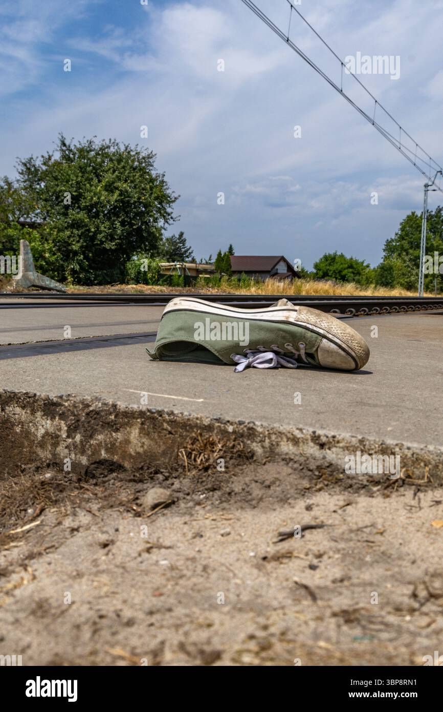 Chaussures de sport vertes près des voies ferrées, une personne heurtée par les voies ferrées à un passage piétonnier, un passage à niveau non surveillé, un suicide s'est jeté en dessous Banque D'Images