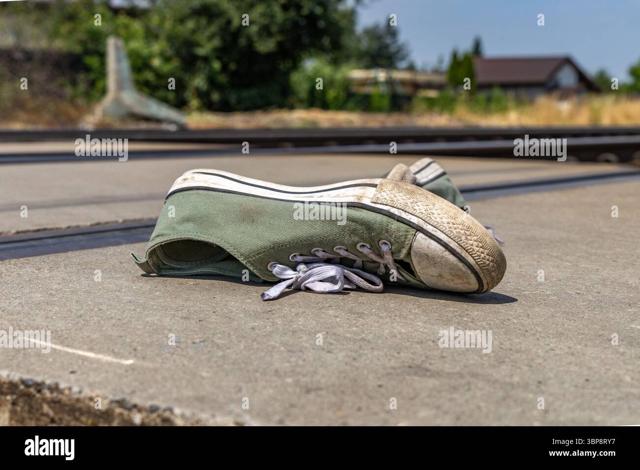 Chaussures de sport vertes près des voies ferrées, une personne heurtée par les voies ferrées à un passage piétonnier, un passage à niveau non surveillé, un suicide s'est jeté en dessous Banque D'Images