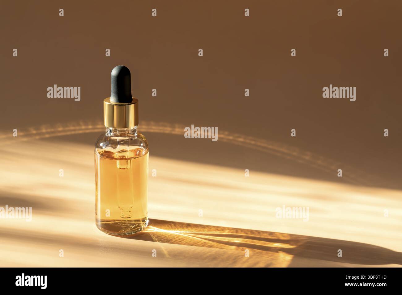 Flacon compte-gouttes en verre Mock-Up. Pipette compte-gouttes avec sérum ou huile essentielle sur fond beige avec ombres caustiques pour la présentation du produit. Soin de la peau c Banque D'Images
