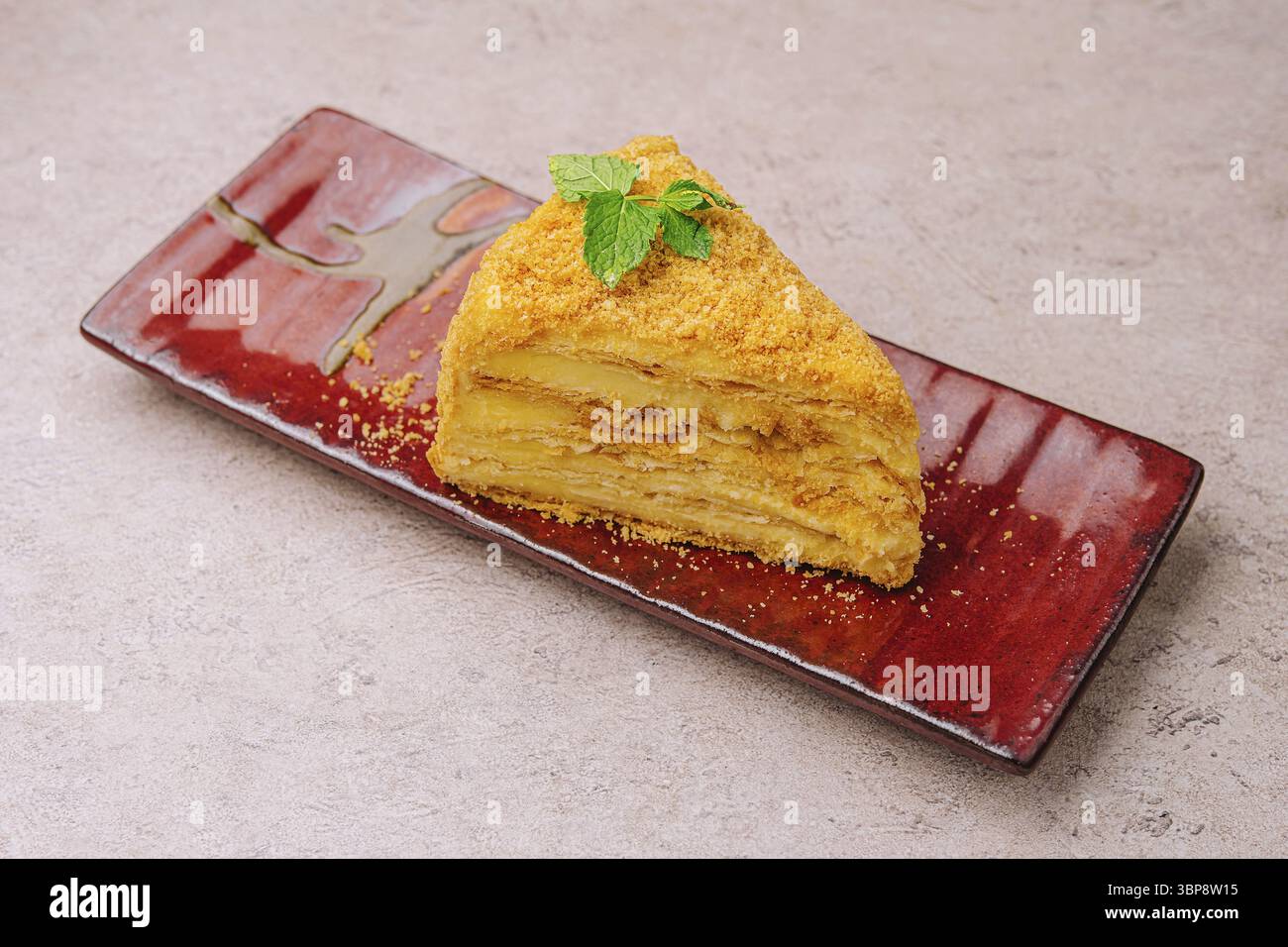 Nourriture, morceau de Napoléon Cake sur assiette rouge Banque D'Images