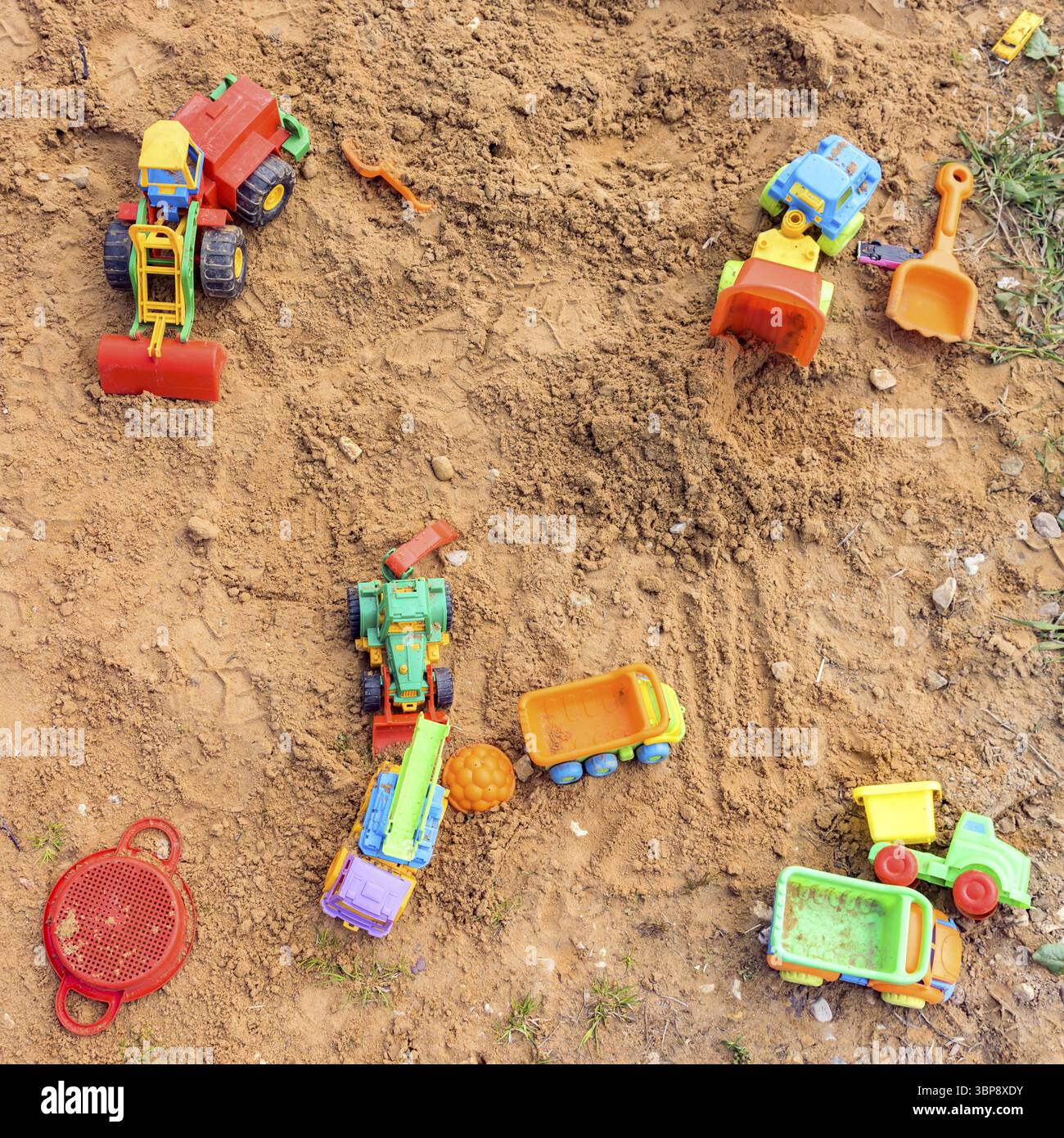 Terrain de jeu avec transport de jouets différent. Camions et pelles hydrauliques pour jouer dans le sable Banque D'Images