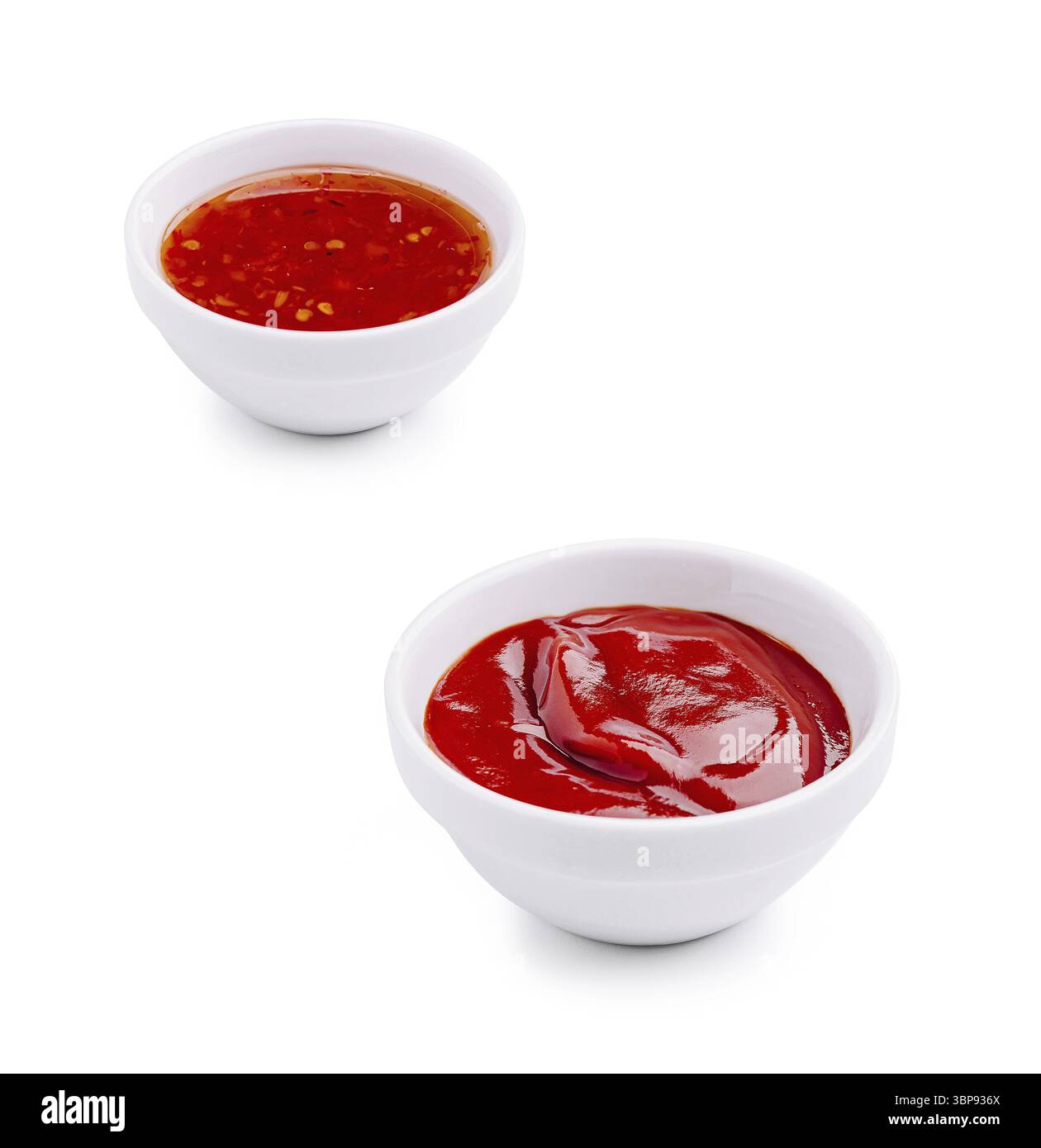 Nourriture, deux petits bols blancs contiennent différents types de sauces. Un bol contient un ketchup rouge vif, tandis que l'autre contient une sauce Chili épicée. Perf Banque D'Images