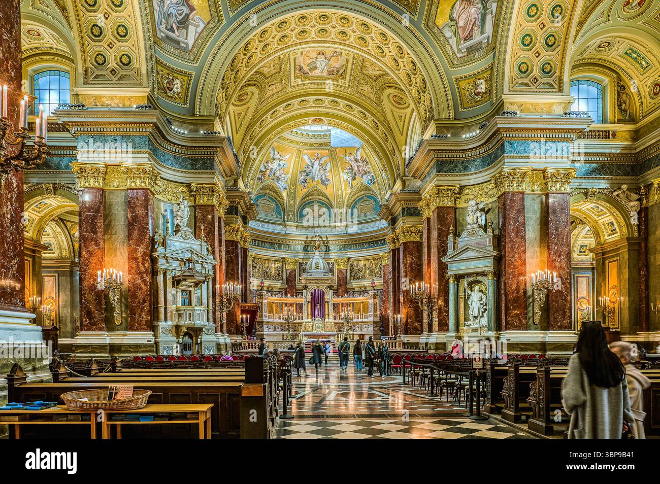 Soyez la basilique de Stephen où les touristes se promènent et regardent l'intérieur doré, Budapest, Hongrie, mars 2025 Banque D'Images