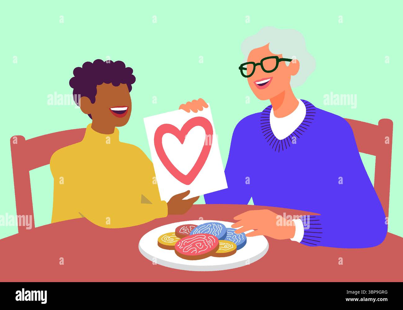 Petit-fils offre un dessin de coeur à sa grand-mère souriante autour de biscuits. Un doux affichage d'amour et de connexion familiale. Banque D'Images