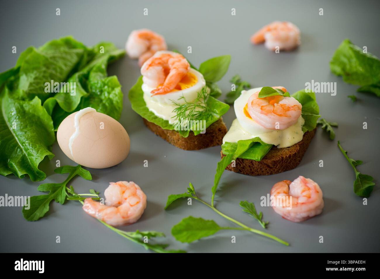 Sandwich avec oeuf et crevettes sur fond gris d'en haut. Banque D'Images