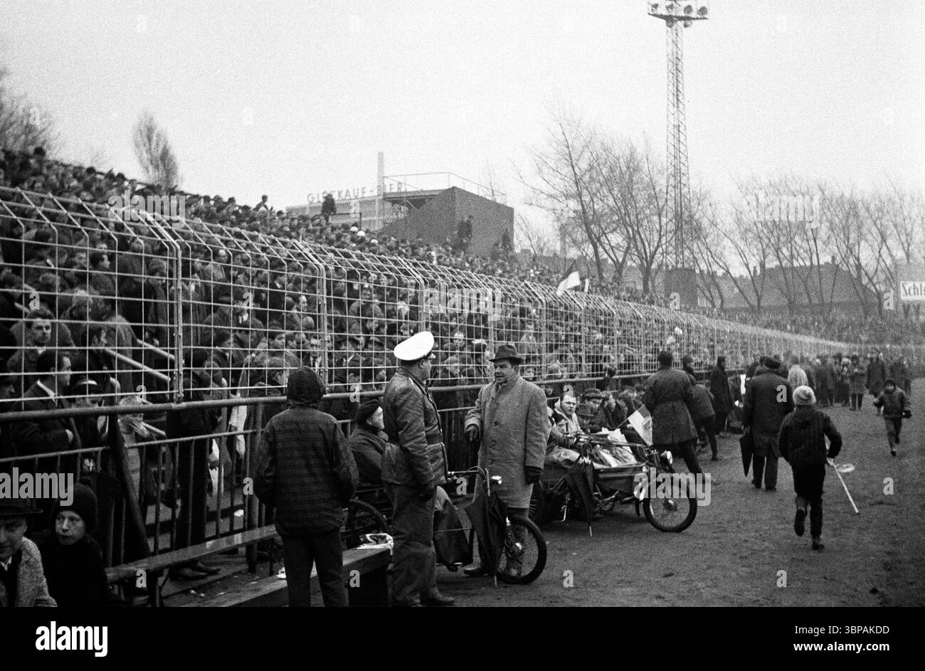 Années soixante, sport, football, Bundesliga, 1965/1966, FC Schalke 04 vs. Hanover 96 1-0, 27.11.1965, stade Glueckaufkampfbahn à Gelsenkirchen, foule de visiteurs, personnes handicapées en fauteuil roulant se tiennent devant la barrière de contrôle des foules Banque D'Images