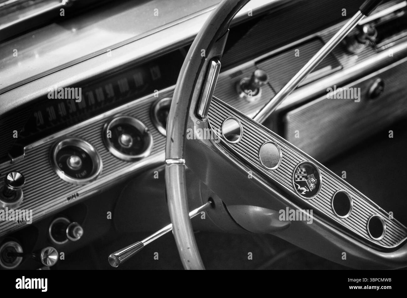 Tableau de bord et volant d'une voiture classique Chevrolet Impala des années 1960 en noir et blanc Banque D'Images