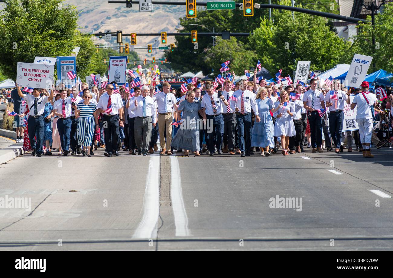 Provo, UT – 4 juillet 2025 : les membres de l’Église de Jésus-Christ des Saints des derniers jours défilent avec des drapeaux américains et des signes de foi lors de la parade du Festival de la liberté. Banque D'Images